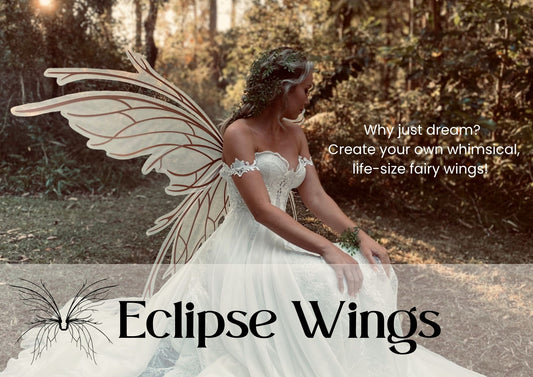 Person wearing large fairy wings sitting outdoors with 'Eclipse Wings' branding.