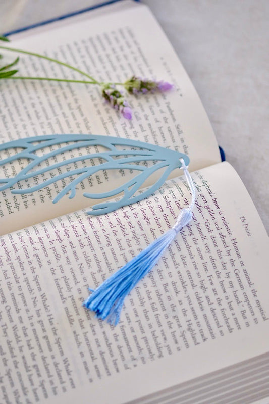 Blue decorative bookmark with tassel on an open book